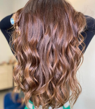 Melena media con ondas en tono cobrizo cálido